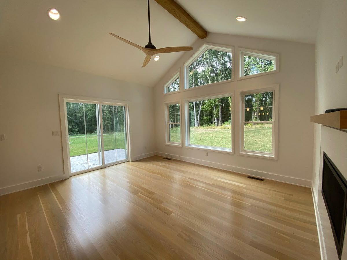 Bright vaulted addition with a fireplace and sliding patio doors by MDR Design-Build-Remodel