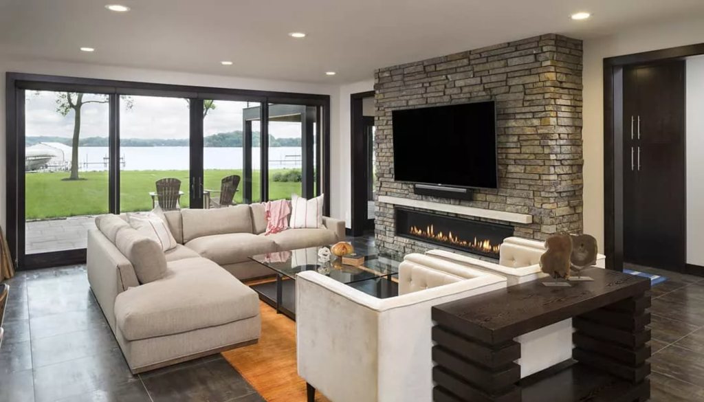 Walkout lower level with large windows and a stone fireplace