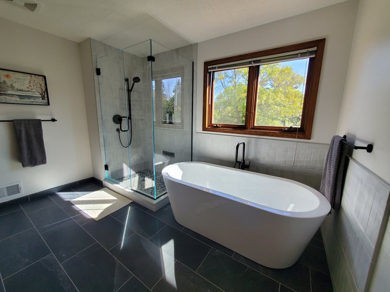 Spa-style bathroom with a freestanding soaking tub and tiled shower — MDR Design-Build-Remodel