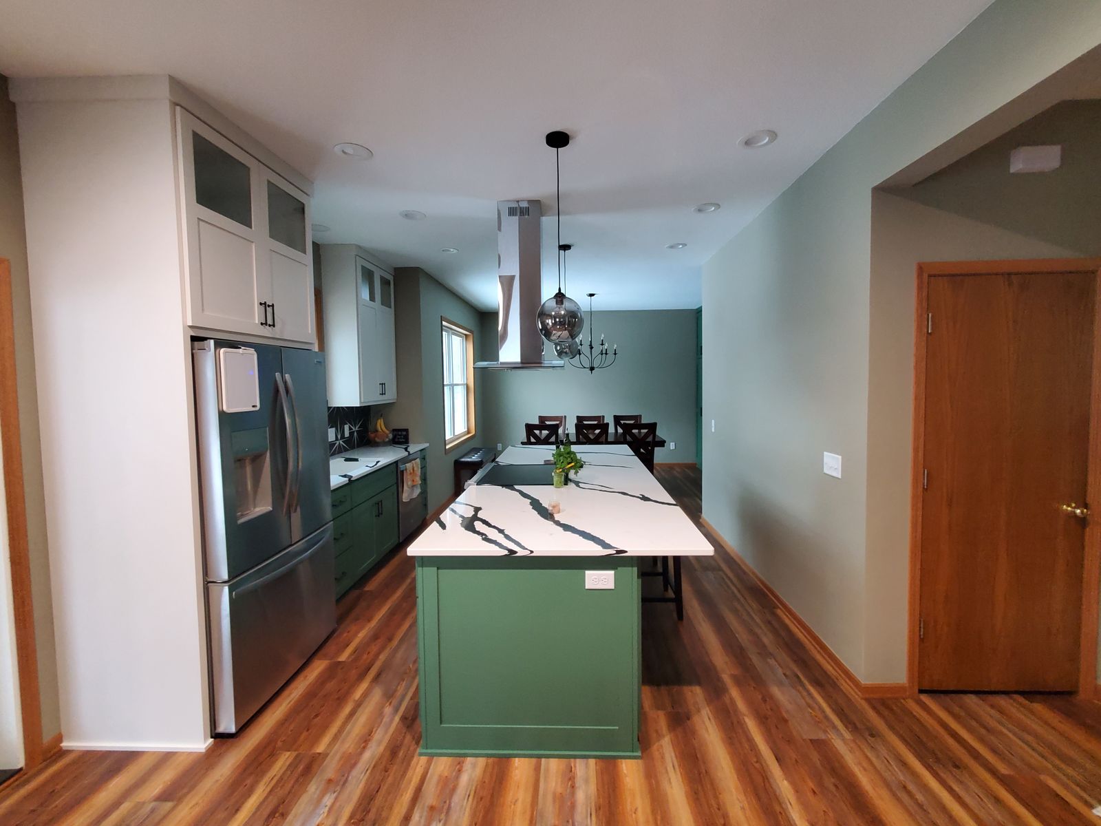 Kitchen remodel with a forest-green island and white upper cabinets by MDR Design-Build-Remodel
