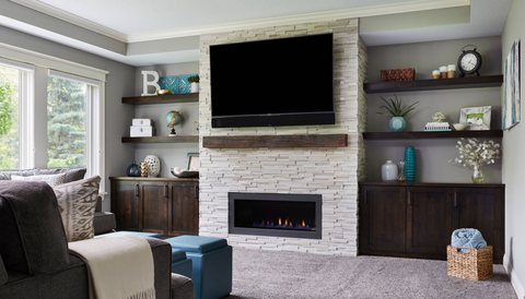 Living room with a stacked-stone fireplace and built-in shelving — MDR Design-Build-Remodel
